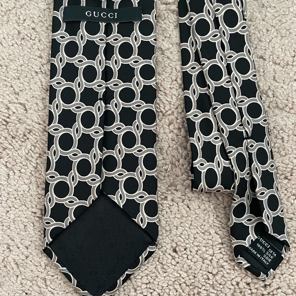 Gucci 100% silk neck tie. Black with silver ring pattern.